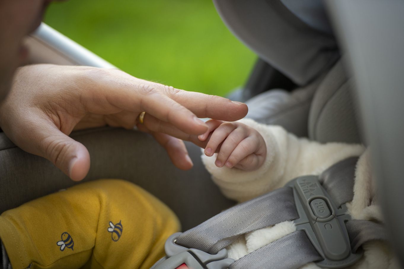 A baby’s hand holding an adult’s finger