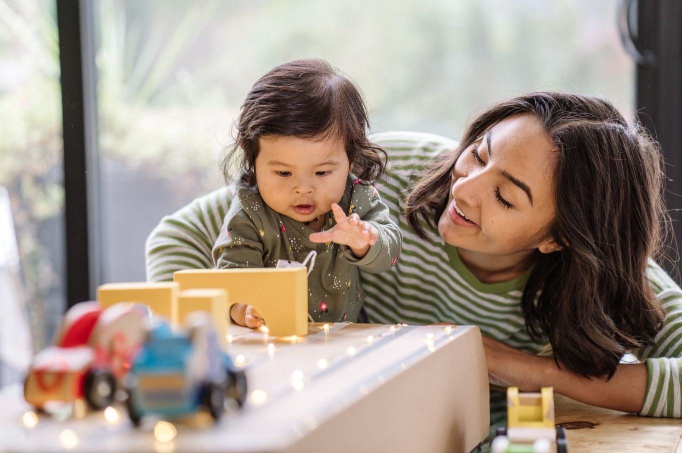A mother and toddler playing together at a table